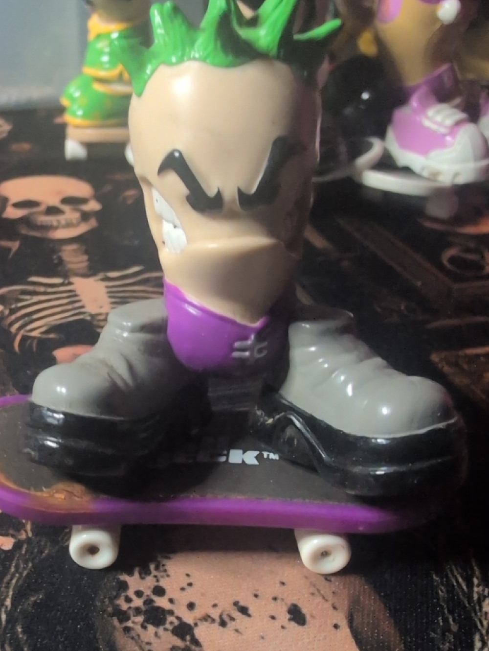 Green-Haired Skate Figure on Purple Skateboard